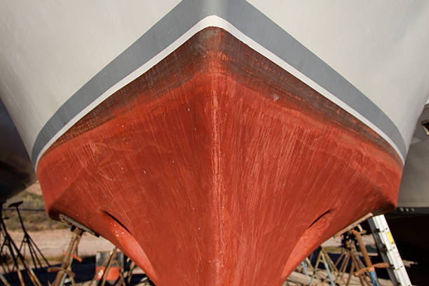 Details of the side of a grey steel plate ship.