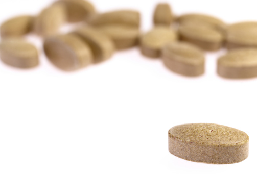 Horizontal close up photo of brown pills