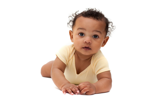 Adorable baby stares straight at camera on against white background.