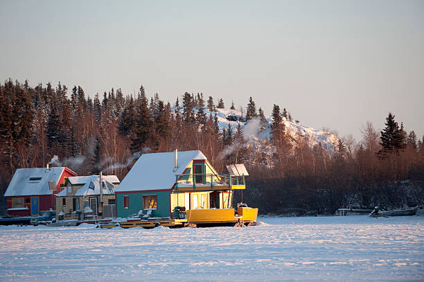 Houseboats Frozen in the Ice. Houseboats on yellowknife Bay in Canada's Northwest Territories waiting for the spring to float again.  Residents live in these year round.  In these images they have noon day sun shining on them as it returns to the arctic.  Click to see similar images. great slave lake stock pictures, royalty-free photos & images