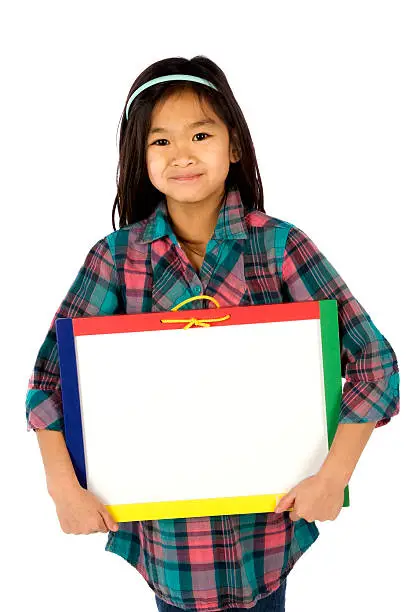 "Little girl holds blank, white dry-erase board with plenty of copy space"