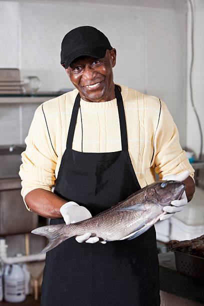 istock Worker holding seabass in fish market 183421985