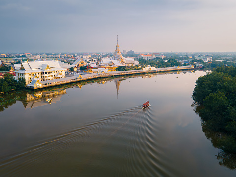 Wat Sothon in the morning, in a reflective view of the water, overlooking the city with temples and rivers with fishing boats. It is a beautiful view.