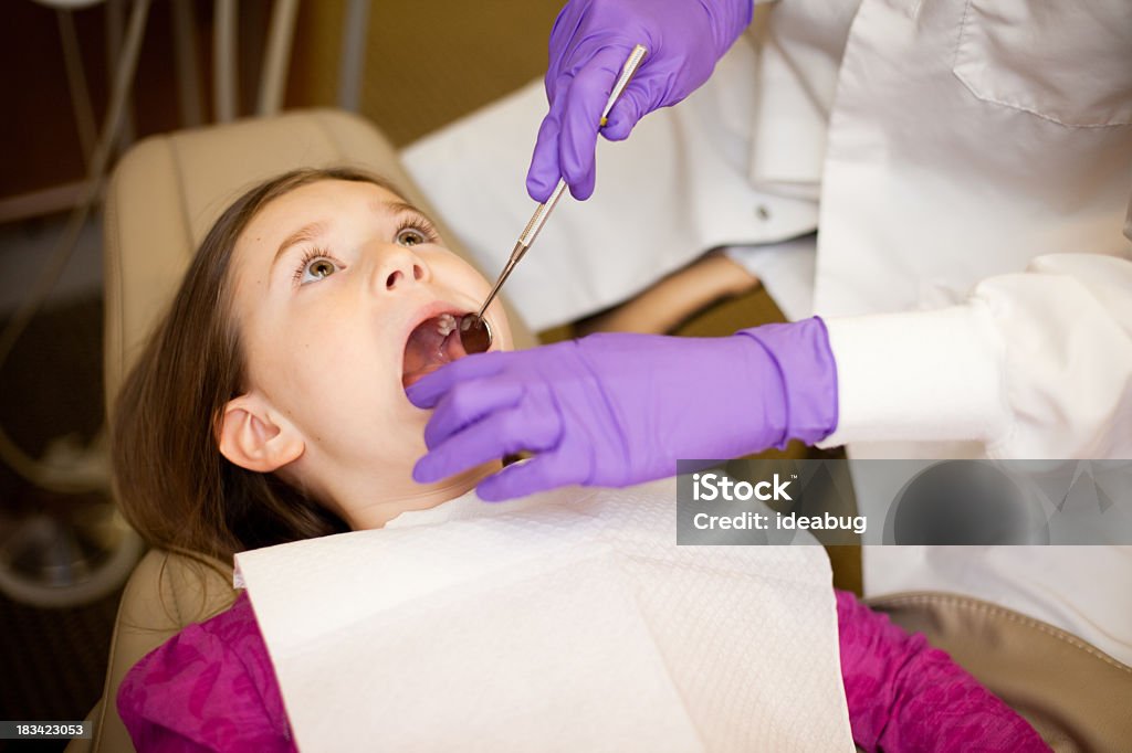 Young Girl primeros dientes examinará en dentistas oficina dentista - Foto de stock de Carie dental libre de derechos