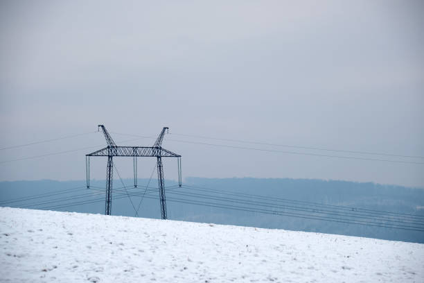 High voltage tower with electric power lines transfening electrical energy through cable wires.