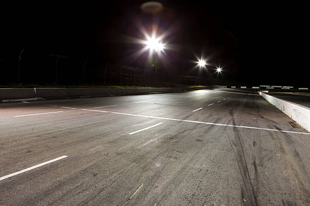 la noche en la pista de carreras - skidding bend danger curve fotografías e imágenes de stock