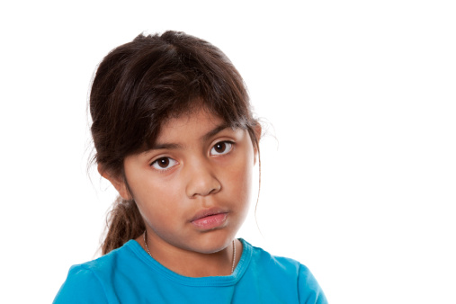 Young Hispanic girl with a sad or serious expression.