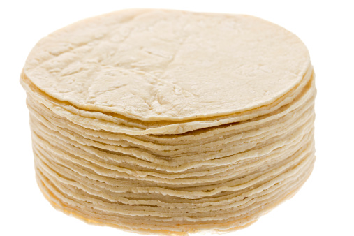A large stack of corn tortilla on a pure white background