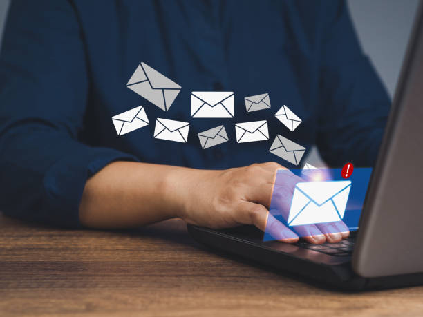 istock Businessman using a laptop receives a new message with email icons while sitting at the table 1834238516