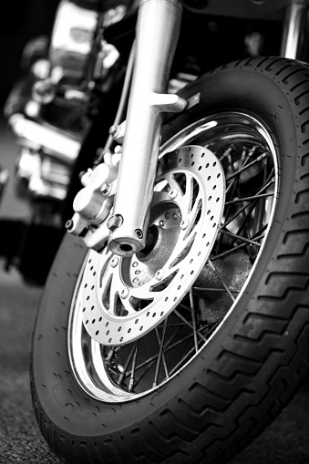 Closeup detail of a motorcycle's front wheel. Monochrom