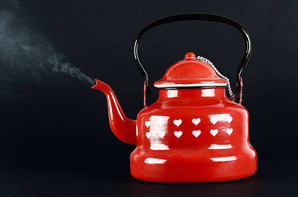 istock Red kettle isolated on black. Steam coming out. 183424471