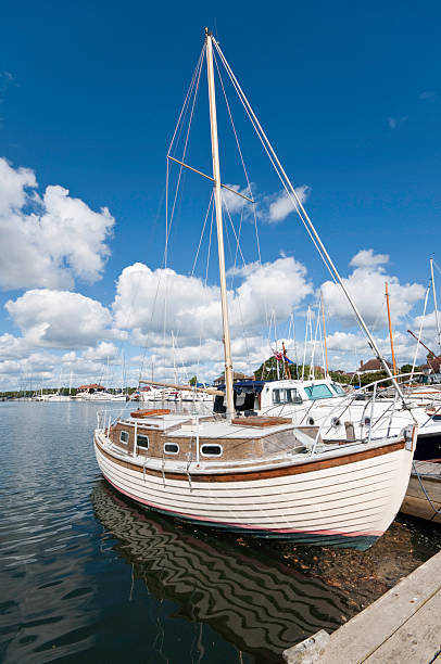 Old Yacht "Old clinker built wooden yacht on pontoon mooring, bright sunny day" chichester stock pictures, royalty-free photos & images