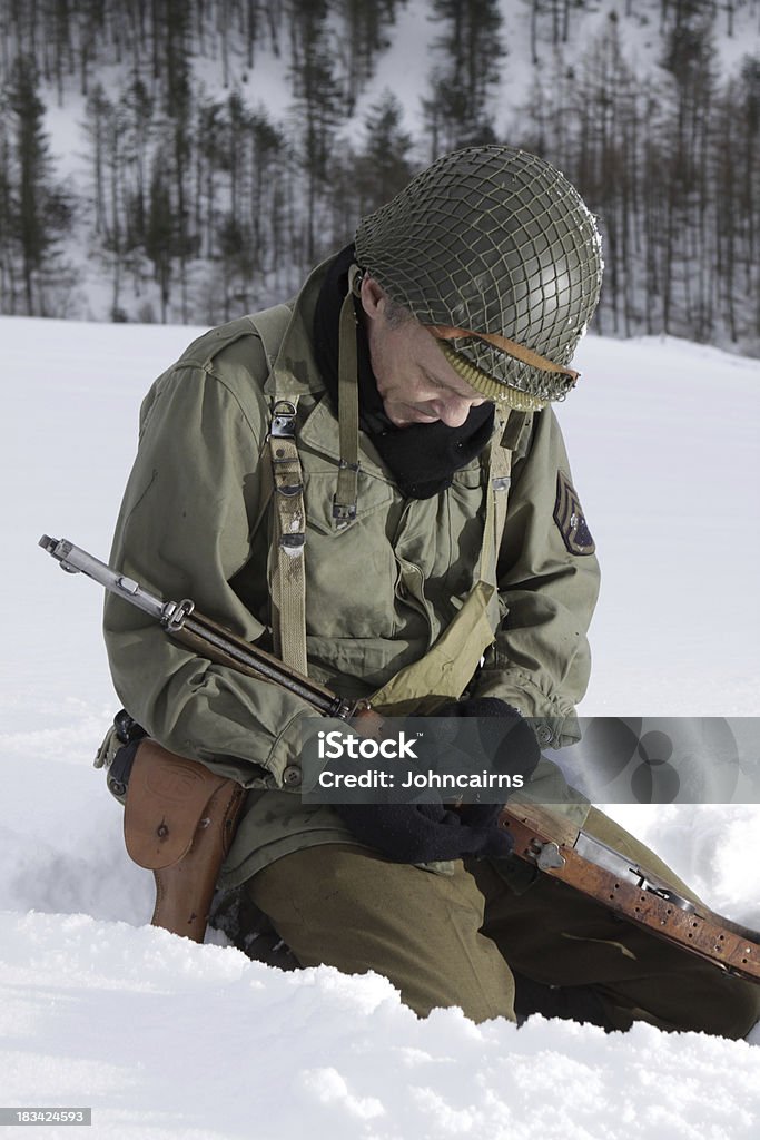 Praying Soldier. WW2 Era US soldier prays during a lull in the fight.Battle of the Bulge re-enactment. Army Soldier Stock Photo