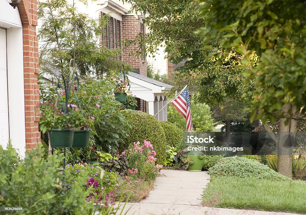 American flag flying in suburban neighborhood Horizontal image of a typical American suburban neighborhood with flag flying. Related: American Culture Stock Photo
