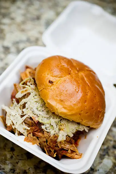 pulled pork sandwich in takeout container