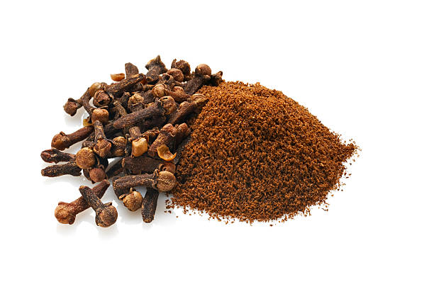 Whole and Ground Cloves, Isolated on White Grouping of whole dried cloves and ground cloves.  Shot on white background with natural reflections.Shot with Nikon D3x and shift lens. clove spice photos stock pictures, royalty-free photos & images