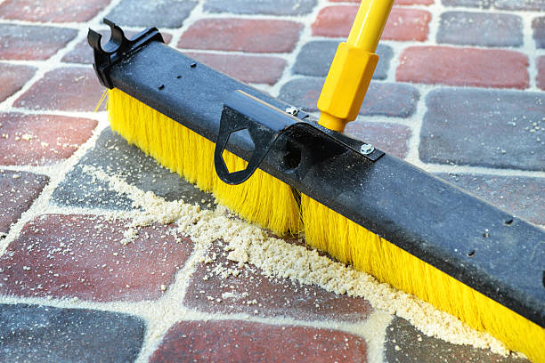 istock Broom Sweeping Sand into Brick Pavers 183425163