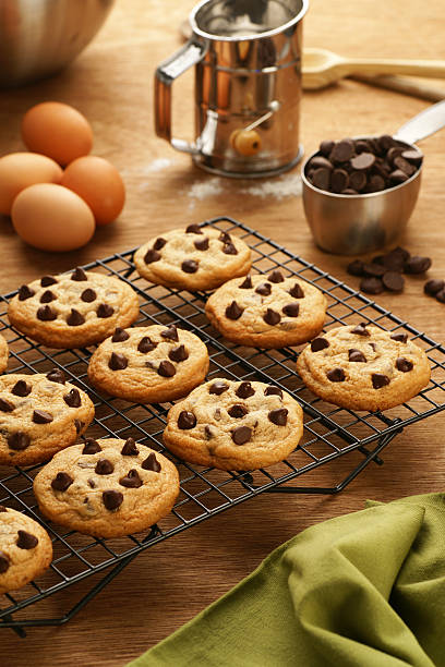 Freshly baked chocolate chip cookies cooling on a cooling rack.