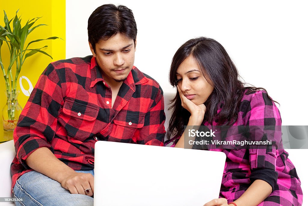 Dwóch młodych dorosłych mężczyzn indyjski kobieta za pomocą laptopa na kanapie Sofa - Zbiór zdjęć royalty-free (20-24 lata)