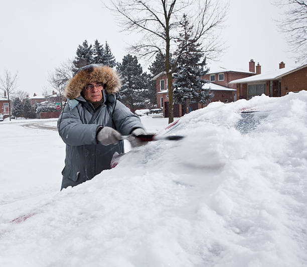 istock Man Cleaning Snow Off Car 183425535