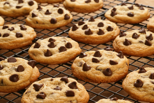 Freshly baked chocolate chip cookies cooling on a cooling rack.