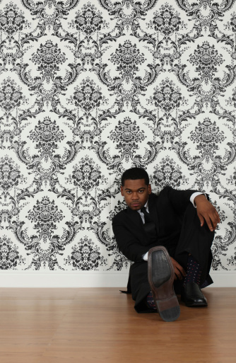 Businessman sitting in front of wallpaper backgroundhttp://www.twodozendesign.info/i/1.png