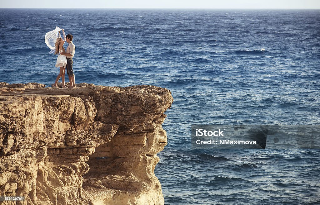 Foto de una pareja en el extremo del Mar acantilado - Foto de stock de Abrazar libre de derechos