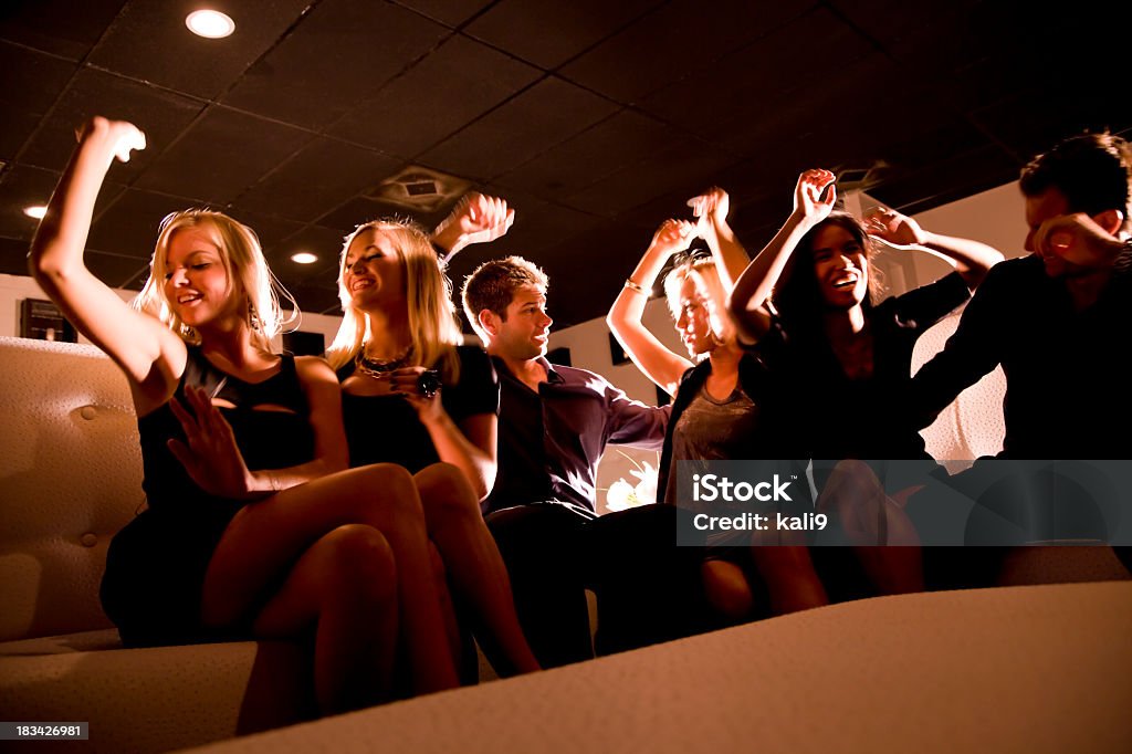 Grupo de danza de la gente en club nocturno en un sofá - Foto de stock de Fiesta libre de derechos