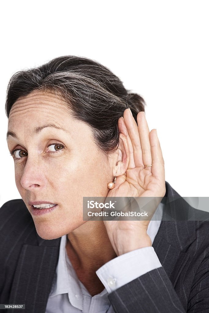 Beautiful businesswoman trying to listen something Portrait of a beautiful businesswoman cupping hand behind her ear isolated on white 40-49 Years Stock Photo