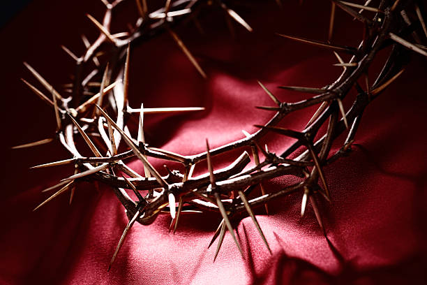 A crown of thorns on a red background.