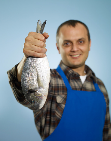 Male fish vendor smiling.