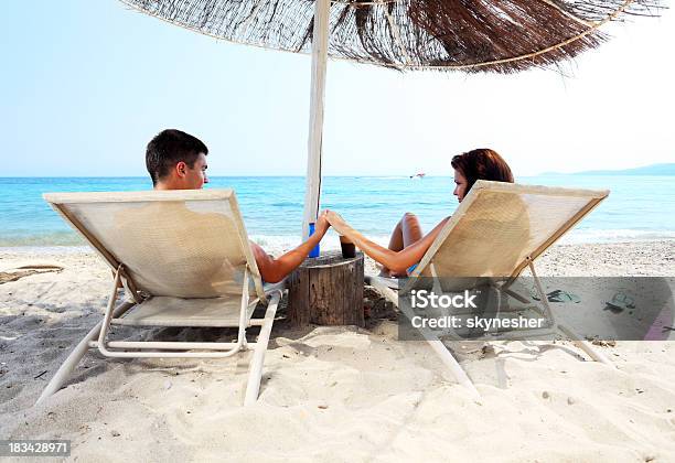 Photo libre de droit de Couple Est Assis Sur La Méridienne Et Profitez banque d'images et plus d'images libres de droit de Plage - Plage, Tous types de couple, Hommes