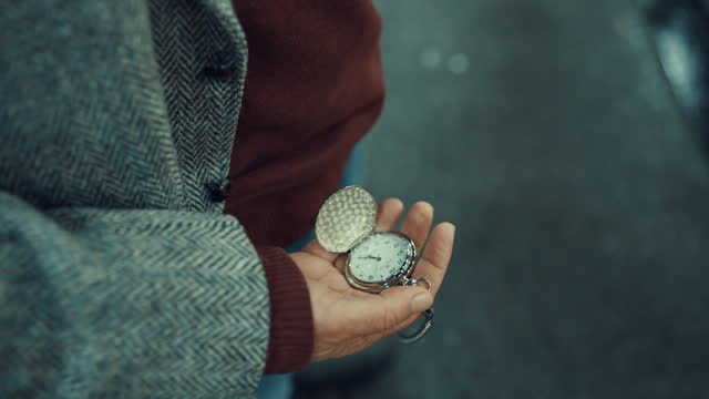 SLO MO Close-Up Tilt Up Shot of Mature Businessman Checking Time on Pocket Watch While Waiting at Bus Stop in City at Night
