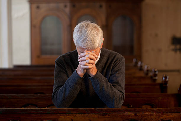 istock Praying senior man in church 183429469