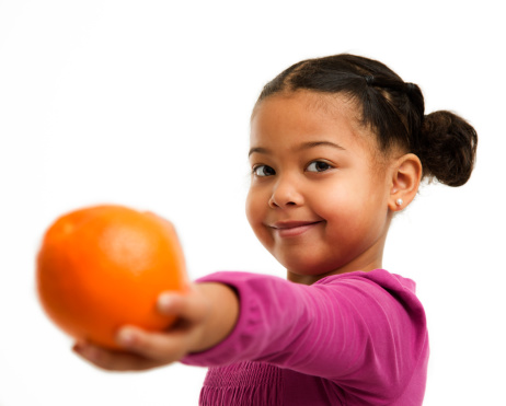 Preschooler offering an Orange to someone.  isolated on white background.
