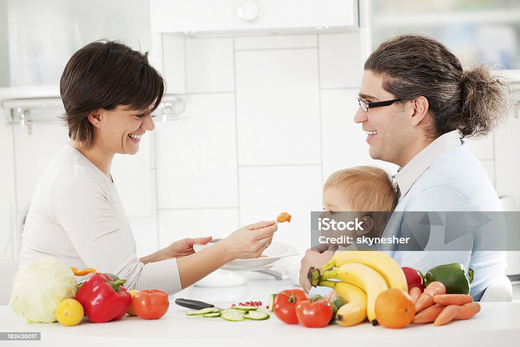 FAMIGLIA FELICE avanzamenti un figlio con Cibo per neonati - Foto stock royalty-free di 12-17 mesi