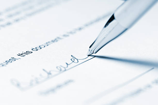 istock Ballpoint pen signing signature on paperwork 183430630