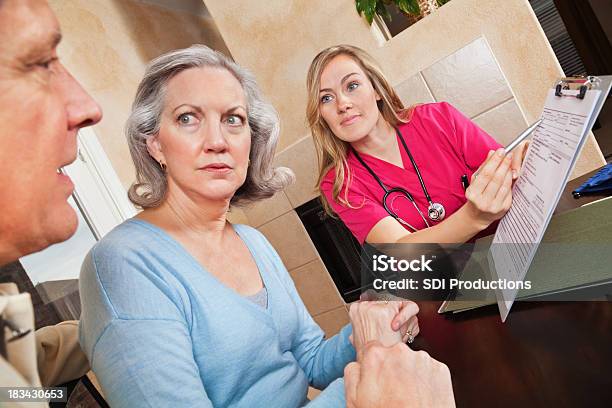 Foto de Enfermeira Mostrando Saúde Formulário Para Preocupação Adulto Casal e mais fotos de stock de Casal
