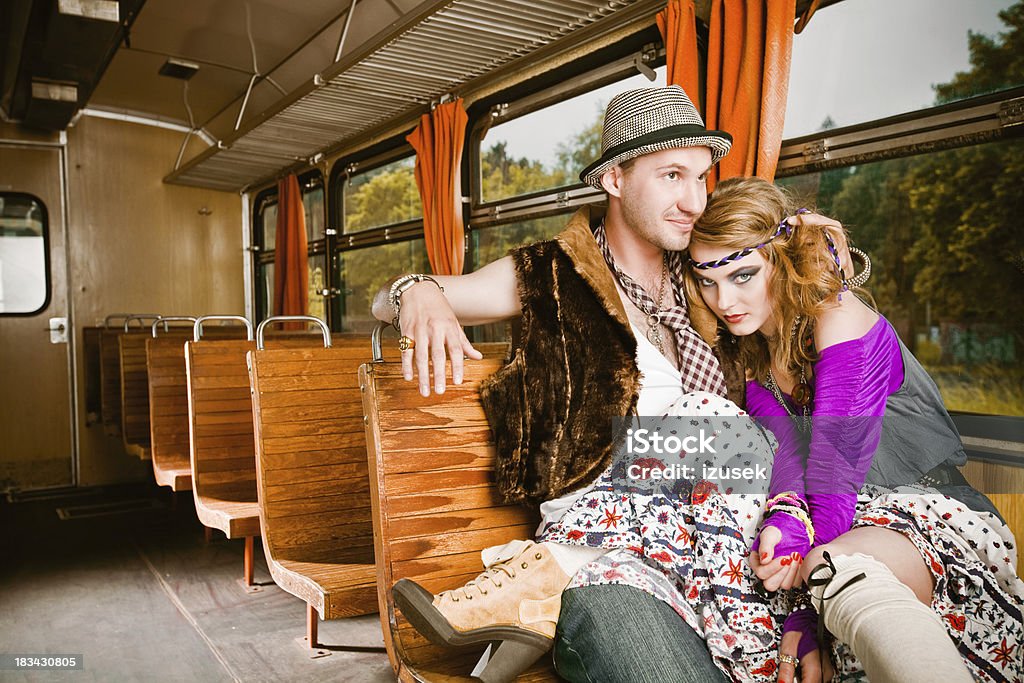 Hippie young couple in a train Fashion portrait of a young adult couple wearing in hippie style sitting in the vintage train. Asking Stock Photo