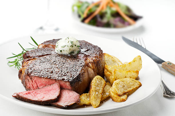 Close up photo of a medium rare steak with potato sidings stock photo