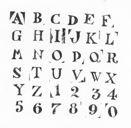 The alphabet  and numbers stamped on a piece of paper in black ink