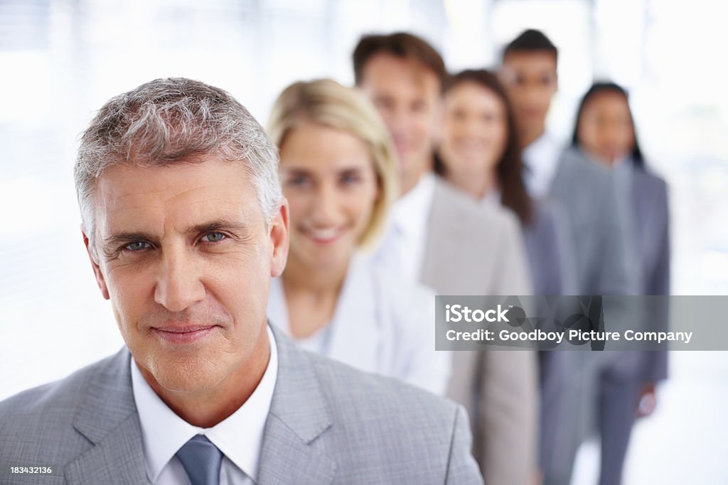 Confident business team in a row Closeup of confident business man with colleagues standing in a row Active Seniors Stock Photo
