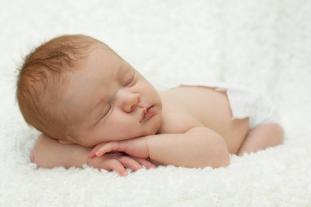Sweet sleeping newborn baby - full length stock photo