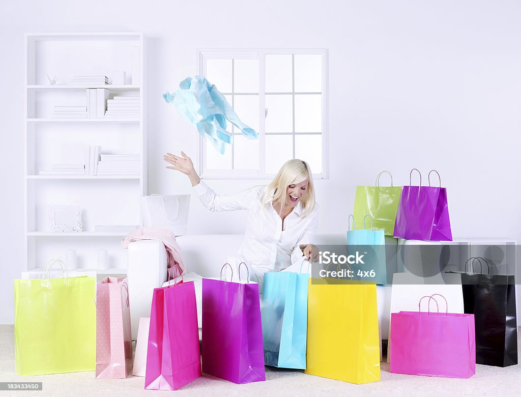Mujer en la sala de estar que se presenta rodeado de bolsas de regalos - Foto de stock de Bolsa de la compra libre de derechos