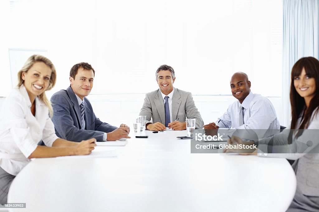 Sonriendo negocios en la mesa de reunión - Foto de stock de 30-39 años libre de derechos