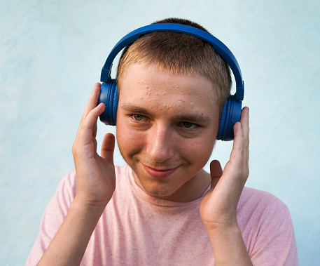 Portrait of a young guy with headphones. Teenage skin problems, acne. lifestyle concept