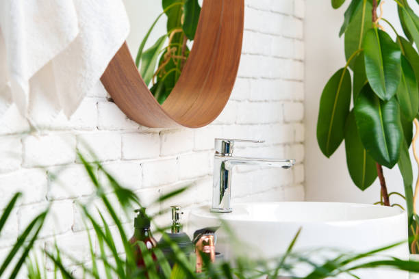 istock Bathroom interior with circle shaped mirror in wooden frame and white sink 1834401627
