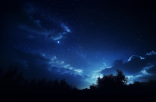 A beautiful clean dark blue night sky with stars and clouds above field of trees. evening sky, night view. illuminated moon. Dark black night. cosmos background.