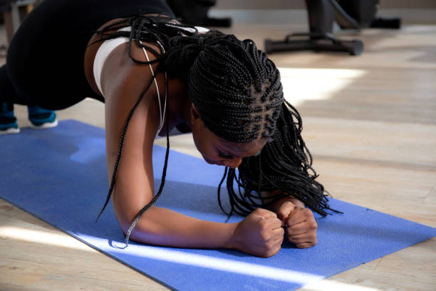 istock Young black woman practice workout with posing plank on mat while motivation and determined at home, female doing weight training with strength and strong, one person, lifestyles and sport concept. 1834417579