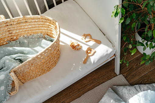 Nursery interior and bedding for kids with wicker bassinet close up